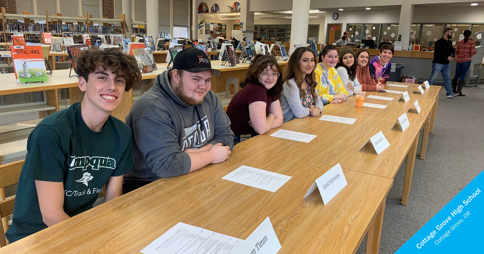 A row of smiling students behind a table at Cottage Grove High School