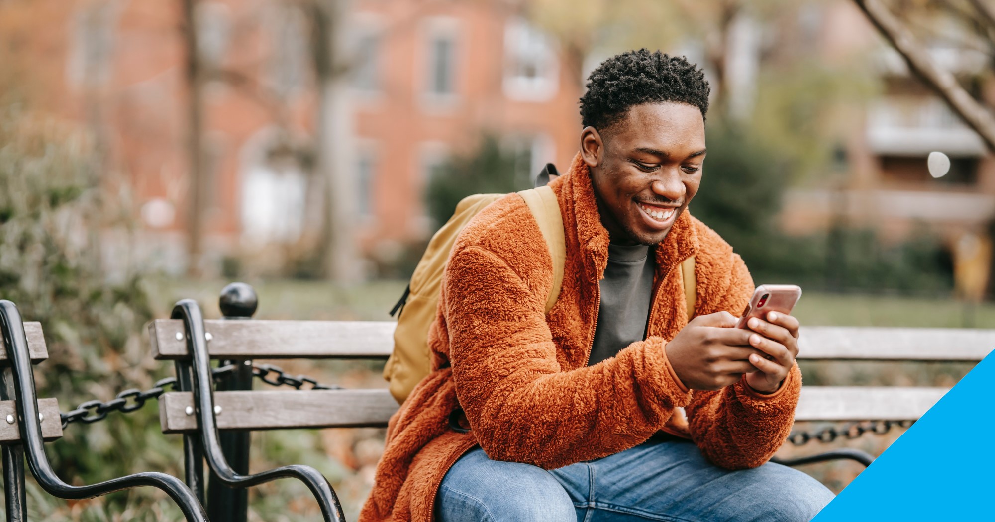Black male smiling and looking at his phone