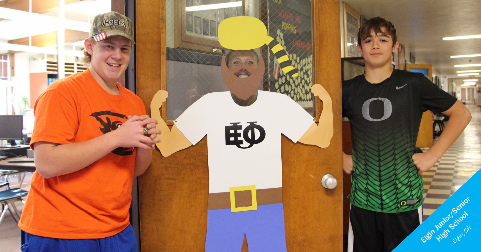Elgin students next to a door display of the EOU Mountaineer