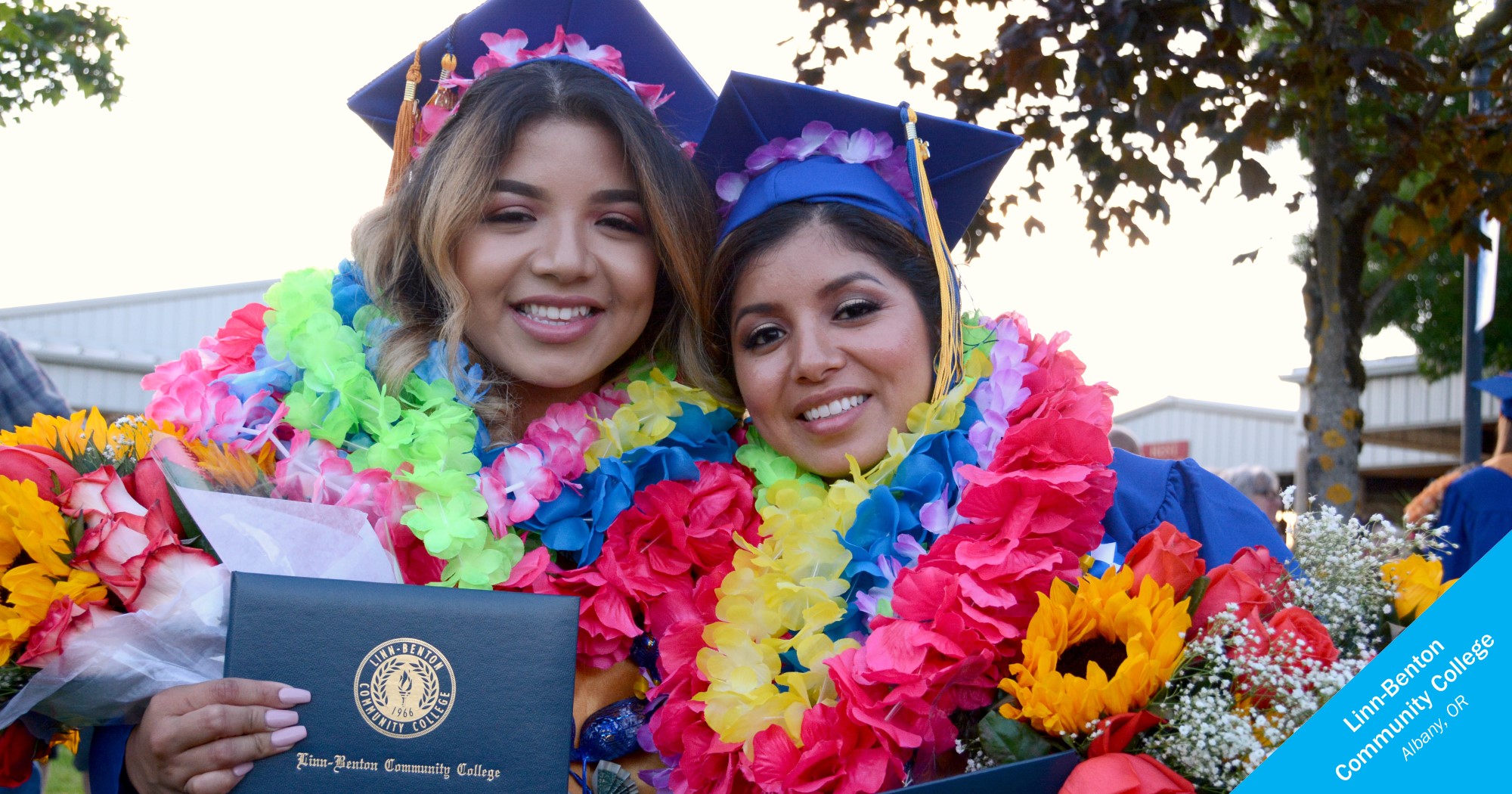 Latina grads from Linn-Benton Community College smiling with leis and flowers