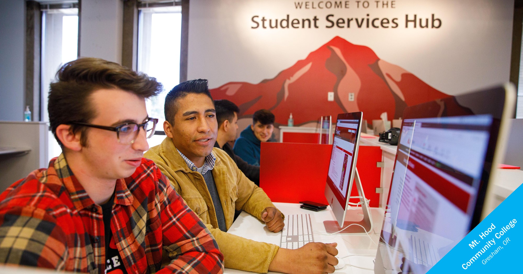 Male students sit in front of a computer at the Student Services Hub at Mt. Hood Community College