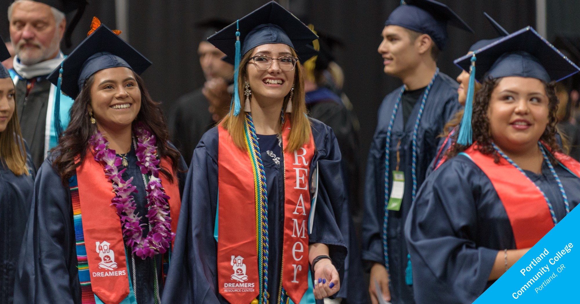 Latina students in graduation robes with Dreamer stoles at Portland Community College