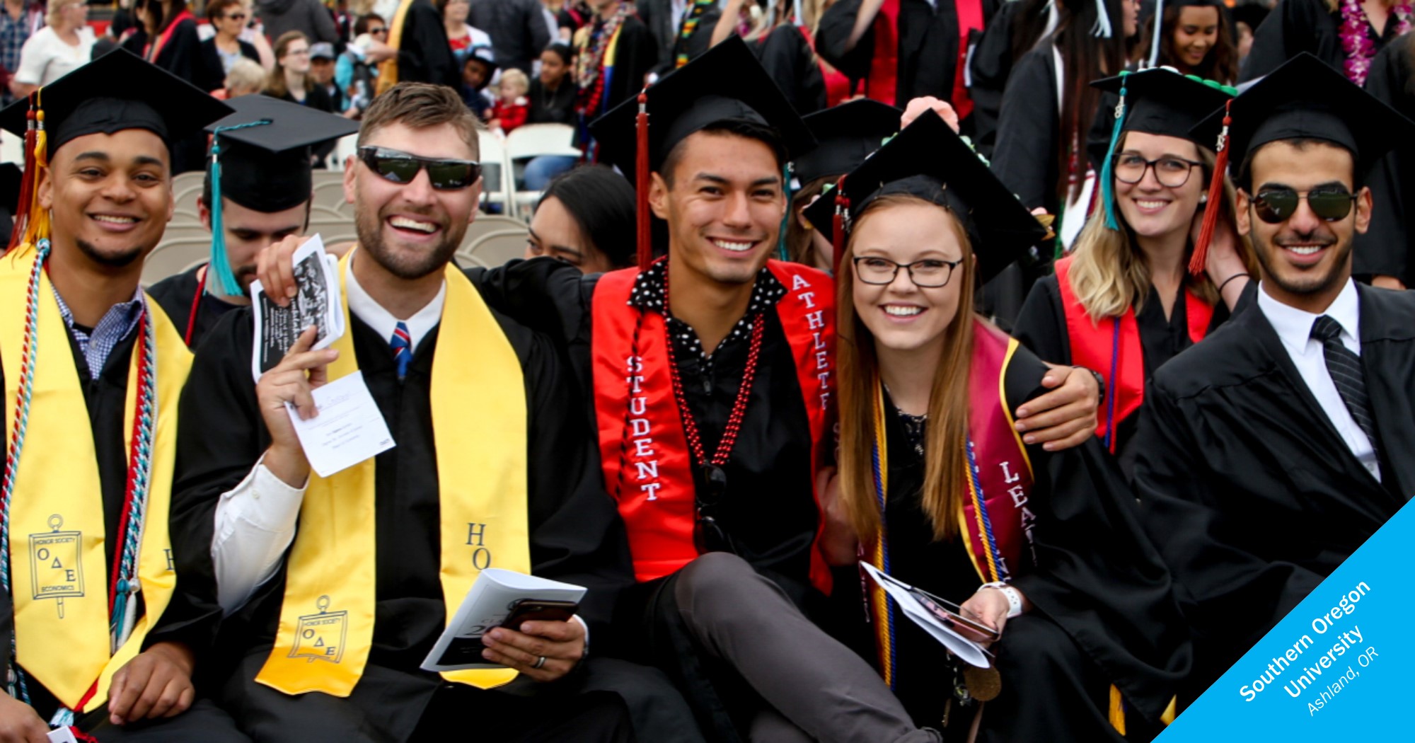 Group of Southern Oregon University smiling graduates