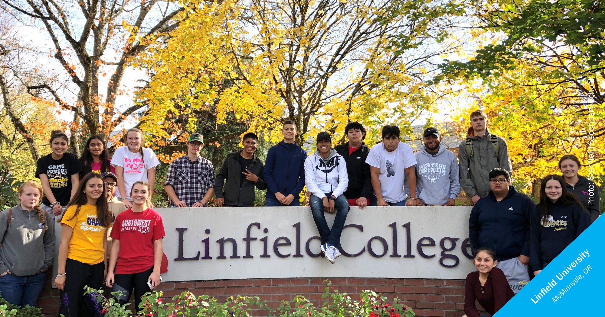 Smiling students in front of a Linfield sign
